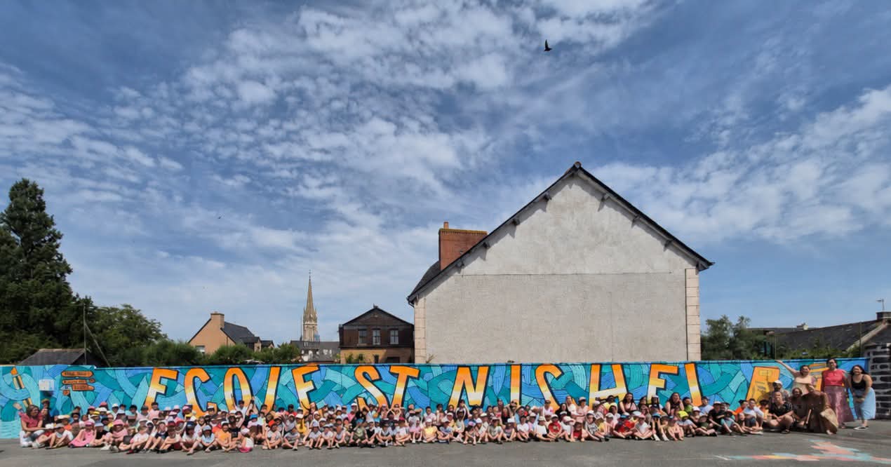 Les élèves réunis devant la fresque de l’école Saint-Michel réalisée en 2026